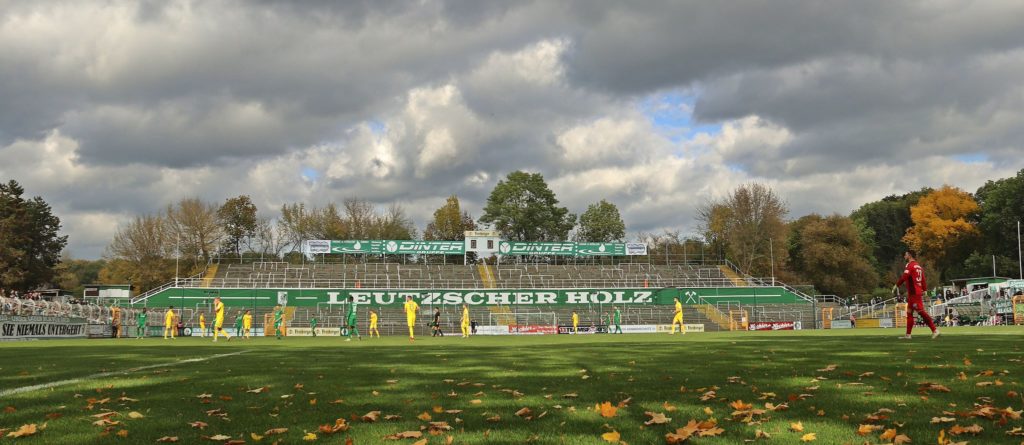 Ein leeres Stimmungszentrum auf dem Leutzscher Norddamm, umrahmt von Fans mit Abstand, dazu eine herbstliche Szenerie. Ein Bild des Spiels der BSG gegen Bischoffswerda